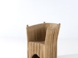 une chaise en osier posée sur une surface blanche