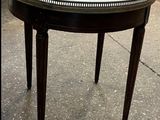 une petite table avec un plateau en marbre posée sur le trottoir