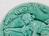 a green plate with a picture of a woman and a dog