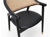 the chair is made of black leather and has a rattan back