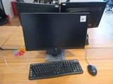 two computer monitors and a keyboard on a desk