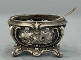an antique silver bowl with a spoon in the middle of it
