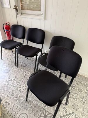 quatre chaises noires alignées dans une pièce