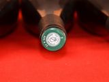 several bottles of wine are lined up in a row on a red surface