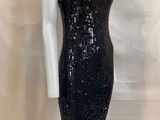 a black sequinned dress with a high neck and long sleeves