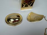 a gold locke with a red rose on it next to a gold necklace