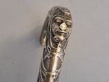 a silver pen with a metal handle on a white surface