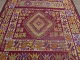 an image of a red and yellow rug on the floor