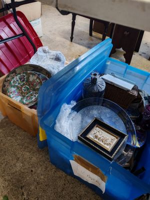 une boîte bleue remplie d'objets, posée par terre