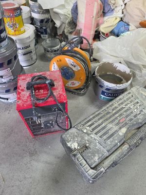 many different types of paint and tools on the floor