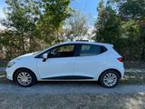 a white car parked on a dirt road in front of trees