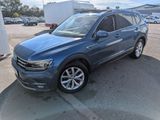 un SUV Volkswagen bleu garé sur un parking à côté d'un immeuble