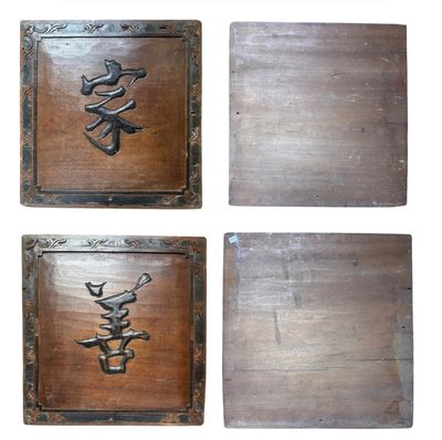 quatre plaques en bois portant des inscriptions en caractères asiatiques sur fond blanc