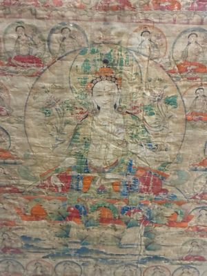 une image représentant un tableau où l'on voit un Bouddha assis sur une table