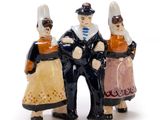 three figurines of a man and a woman standing next to each other
