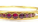 an image of a close up of a gold bracelet with red stones