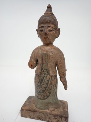 une vieille statue représentant une personne portant un chapeau et une robe