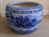 un grand vase bleu et blanc posé par terre