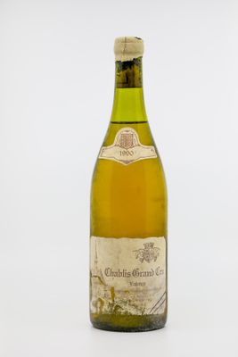 une vieille bouteille de vin posée sur une table blanche