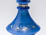 une bouteille en verre bleue ornée d'un motif doré