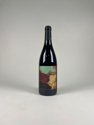a bottle of wine sitting on top of a white table