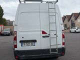a white van parked in a parking lot with a ladder on the back of the van