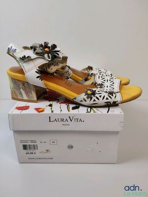 Les chaussures sont blanches et jaunes, avec des fleurs dessus.