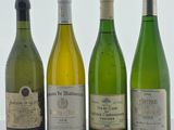 quatre bouteilles de vin sont alignées sur une table