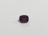 a square cut purple sapphire stone on a white surface