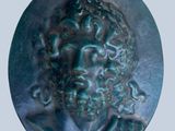 a close up of a bronze medallion of a man with curly hair