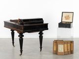 un piano et une boîte posée par terre dans une pièce