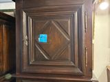 a tall wooden cabinet with a blue sticker on it