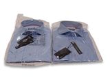 two blue shirts wrapped in plastic bags on a white surface