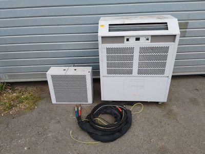 two air conditioners sitting next to each other on the ground