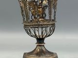 an image of a silver vase with a dragon on it