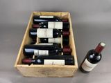 bottles of wine are in a wooden box on a table