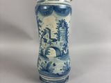 un vase bleu et blanc posé sur une surface blanche