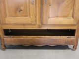 a wooden cabinet with two doors and a drawer underneath it