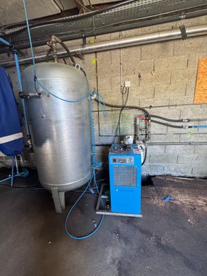 un grand réservoir situé à côté d'une machine bleue
