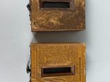 two old wooden boxes are sitting next to each other on a white surface