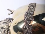 a golden egg with a chain around it on a white surface