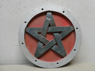 une étoile rouge et noire sur une plaque métallique