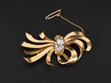 une broche en or et diamants avec une chaîne
