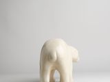 a small white elephant figurine standing on a white surface