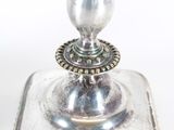 a silver plate with a candle holder on top of it