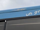 a blue bus that has a sign on the side of it