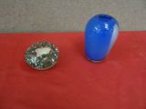 a blue vase and a silver candle holder on a red table