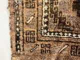 a very old rug on the floor next to a wall