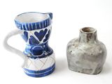 two vases sitting next to each other on a white surface