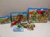 Il y a trois figurines Playmobil sur la table, dont une avec un toboggan.